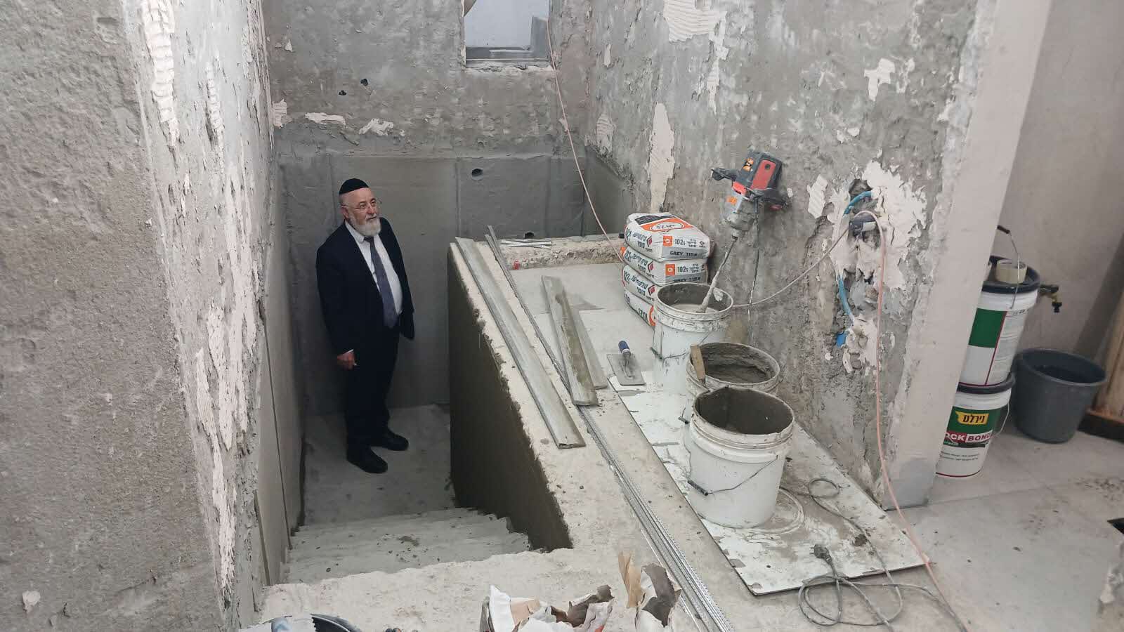 הרב דהן סוקר את בור המקווה. א' מיכאלי