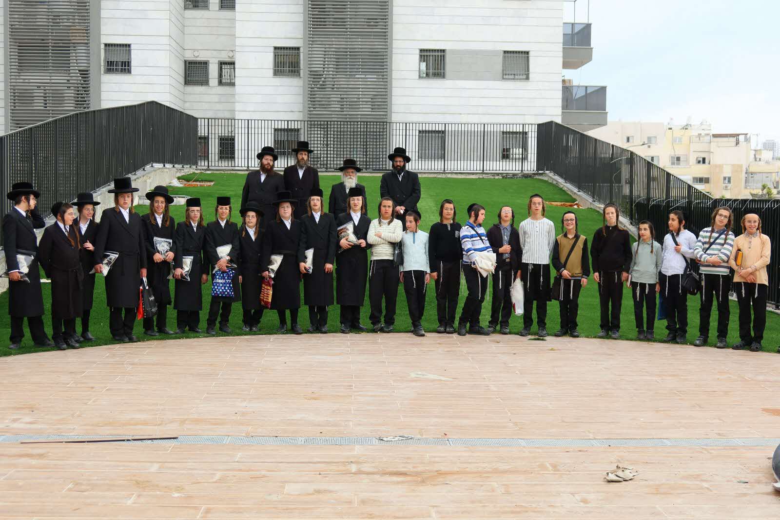 תלמידי הת"ת הכלל חסידי על רקע הבנין החדש. דעת מישרים