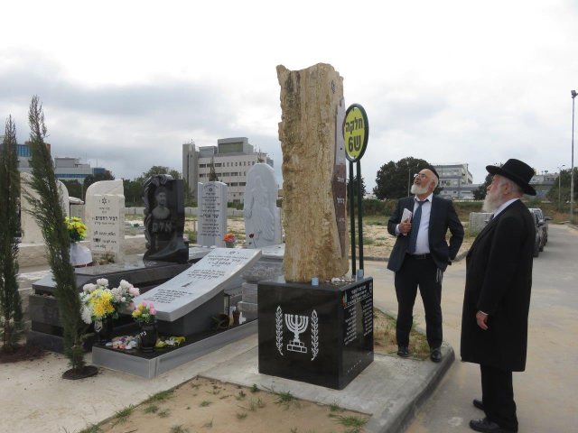 הרב שיינין על קברי הנרצחים. צילום: א. מיכאלי