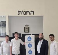 הזוכה המאושר עם ארגזי הספרים. לצידו, יו"ר מוסד הרב קוק, הרב יהודה רפאל