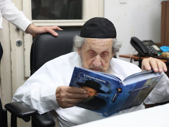 מרן הגרדל מעיין בספר החדש. המצלם