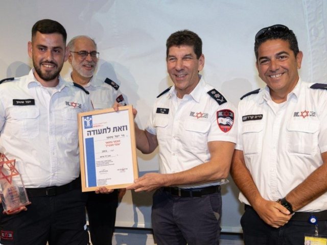 מנכ״ל מד״א אלי בין מעניק את תעודת ההצטיינות ליובל שטמן