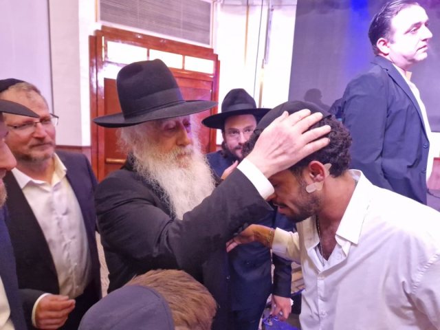 האדמור רבי דוד פינטו מברך את אחד הניצולים. א' מיכאלי